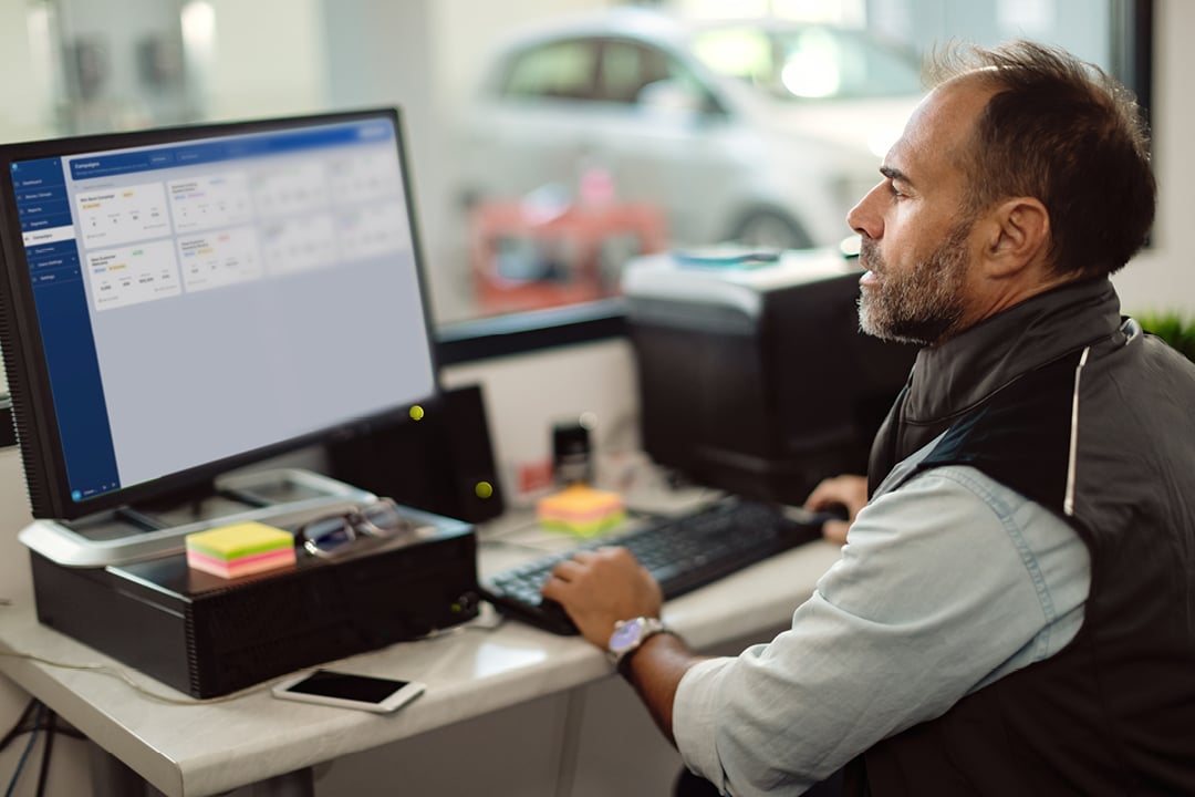 Foreman working on a desktop computer in an auto repair office