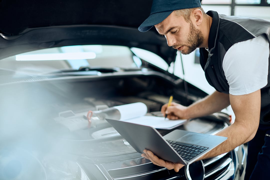 Mechanic using laptop during engine maintenance