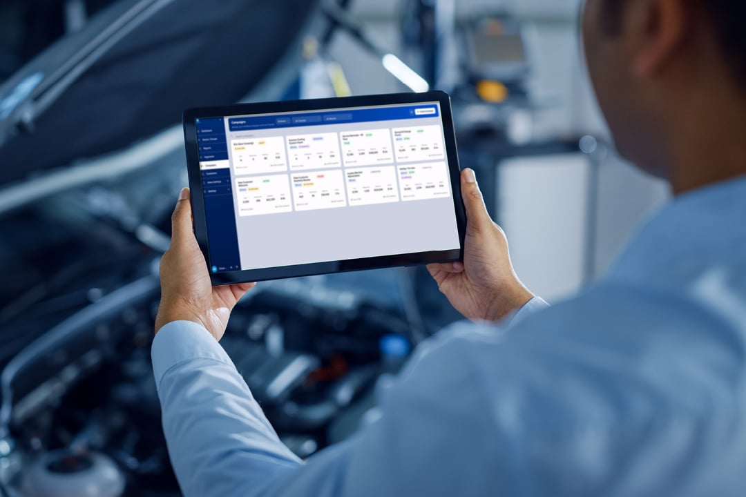 Autobody shop manager using a tablet in a garage