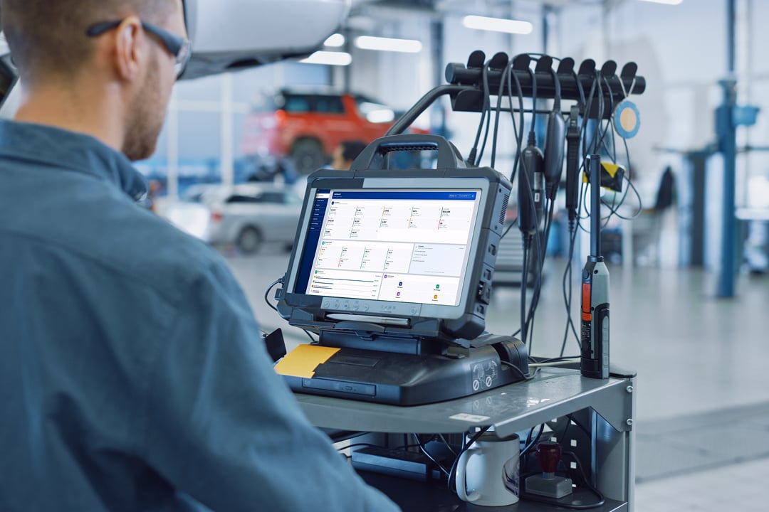 Mechanic using a tablet computer in an auto repair shop
