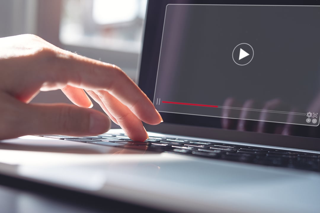 Woman watching webinar or training video on laptop